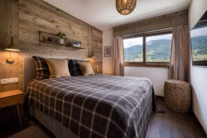 Megeve chalet bedroom bed shelf pillows view nature